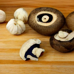 garlic that has been peeled and portabella mushrooms that have been cut into thin slices.