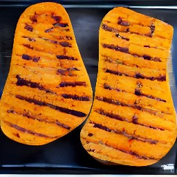 the butter mixture is spread over the butternut squash, and then salt and black pepper are sprinkled over them.