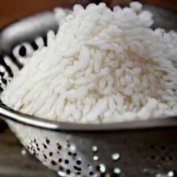 white rice that has been rinsed and drained in a colander.