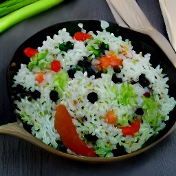 a dish with black beans and rice, scattered with coriander and drizzled with lime juice.